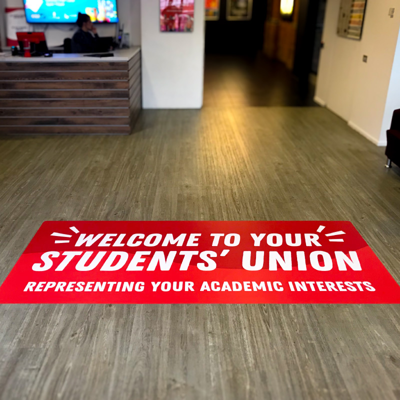 A red graphic on the floor welcoming visitors to Lincoln Students Union